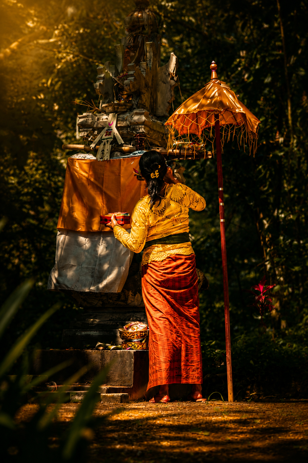 Morning offering beneath a golden temple umbrella